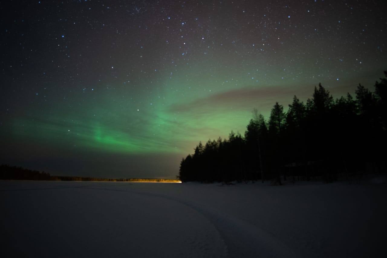 Northern lights over a frozen lake in Lapland on a winter night